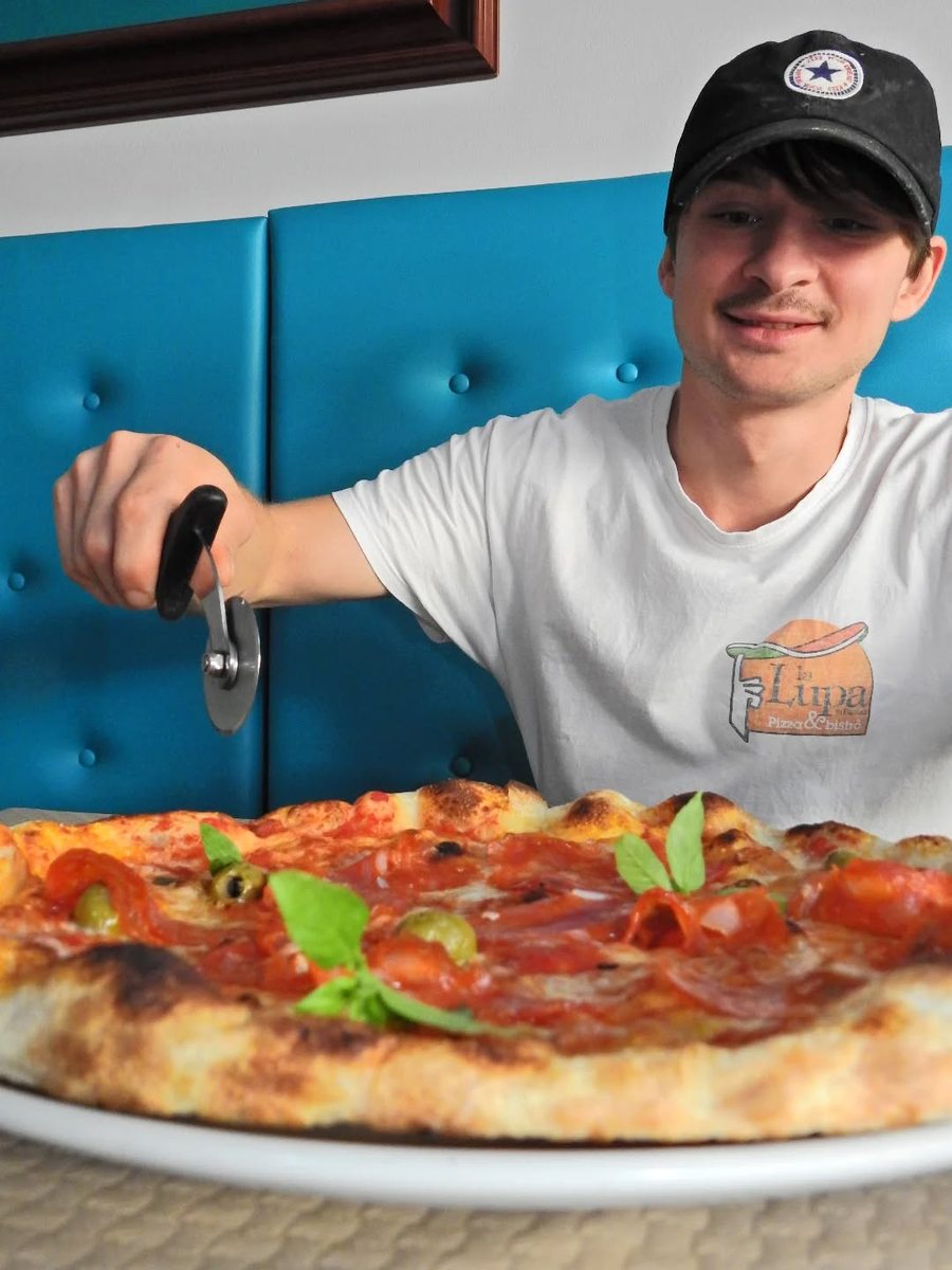 Staff cutting a fresh pizza at La Lupa, Tavira